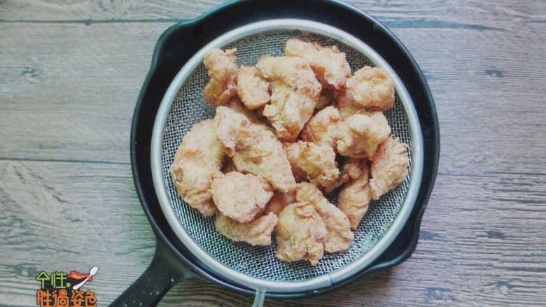 吮指蒜香盐酥鸡,这时候把油再次烧热,把刚才捞出来的鸡块再炸一遍,炸到金黄色就可以捞出来了,别炸太久糊了