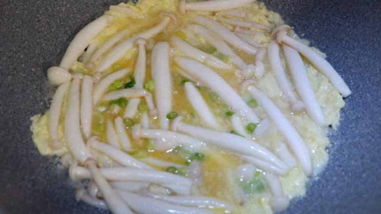 快手菜—蟹味菇嫩滑蛋,煎至表面快要凝固的时候,开始翻炒。