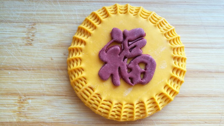 蔓越莓“福”馒头,用“福”字印模印出福字,抹上水沾到黄色面团的中间。