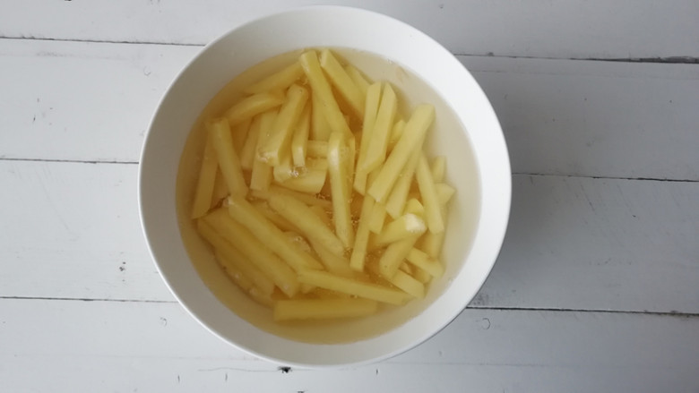 干煸土豆条,将土豆切成1厘米厚的片,再切成条,放在清水中洗去淀粉,捞出控水
