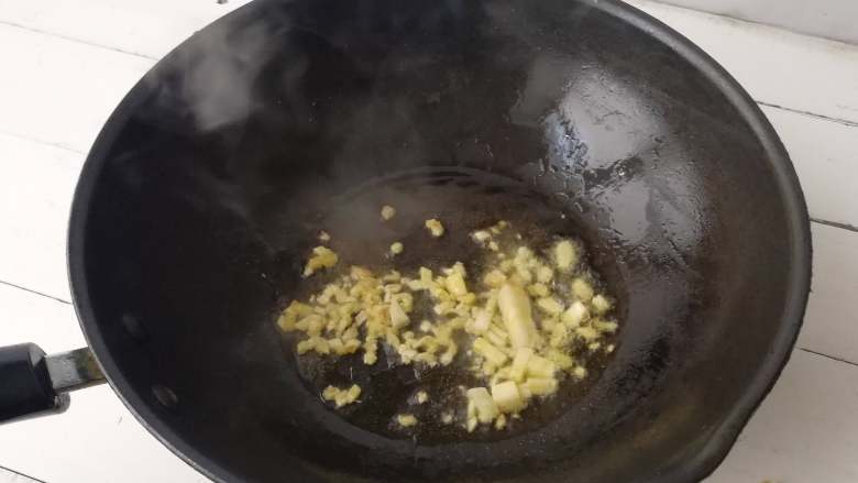 干煸土豆条,下入姜末,蒜片爆香