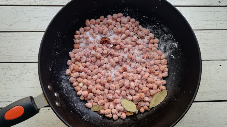 盐炒花生米,开始炒制时,因为花生米有水分,盐会将花生米包裹住