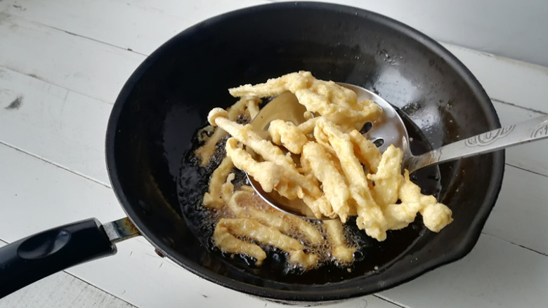 干炸鸡腿菇,锅加油烧热,5-6成热,先下入一条,周围起密集的小泡,油温就可以了,将鸡腿菇逐条下入油锅里,将蘑菇炸至定型,捞出
