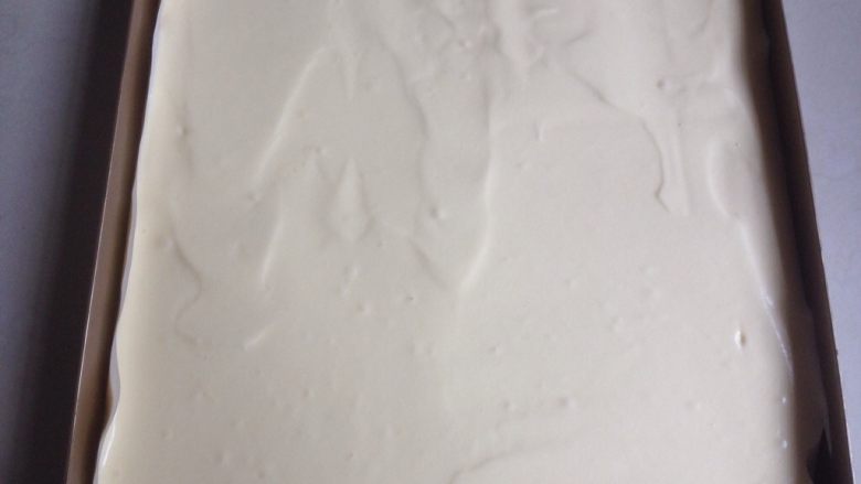 奥利奥蛋糕卷,倒入28*28CM正方形烤盘里(烤盘内铺一张油纸方便脱模),用刮板刮平蛋糕糊表面,在桌面上震出大气泡