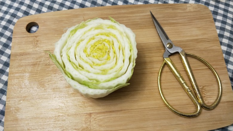 美味和颜值并存的白菜包肉,用剪刀将白菜杆子修剪,将每一片修成弧形