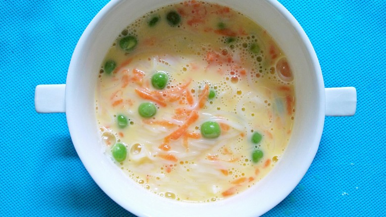 蝴蝶面羹,依次把胡萝卜丝,豌豆,原味细面加入蛋液里,搅拌均匀