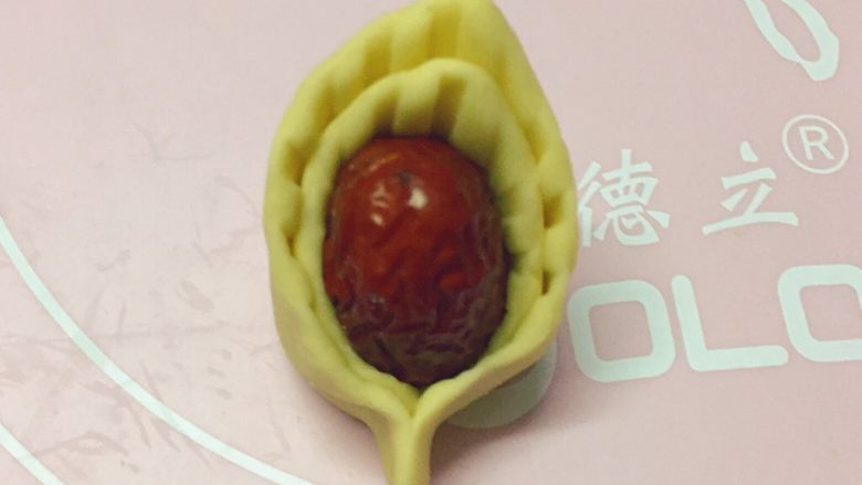 新年喜庆枣花馍,如图:两头用手捏紧,一个花瓣就制作完成了。