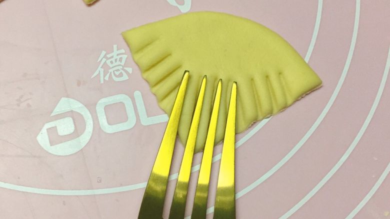 新年喜庆枣花馍,如图:拿叉子在小三角上按出花纹。