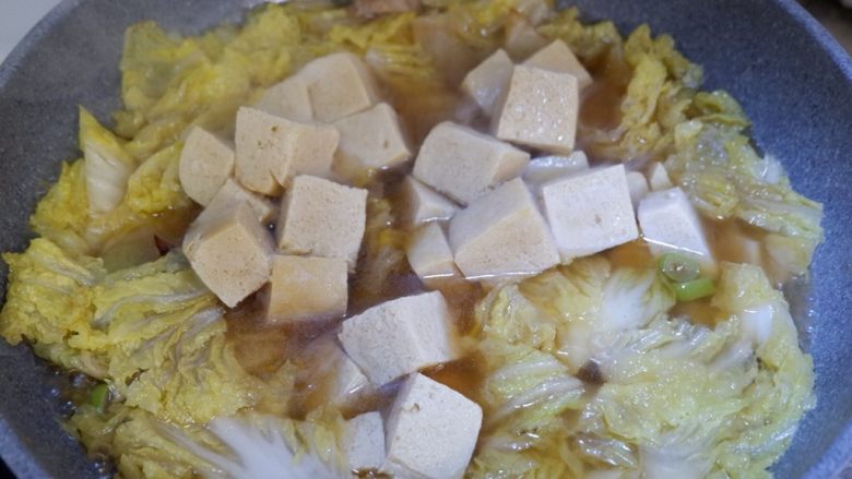 五花肉炖白菜冻豆腐,锅内水开后,加入冻豆腐。