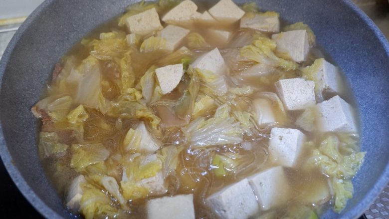 五花肉炖白菜冻豆腐,最后打开锅盖,将粉条与其他食材拌匀。