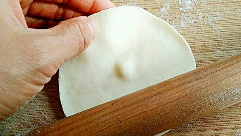 素饺子,将面剂压扁,擀成中间后边缘薄的饺子皮。