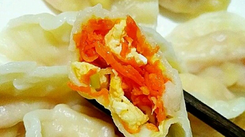 素饺子,一家人围坐桌旁,吃着自己动手包的饺子,其乐融融。