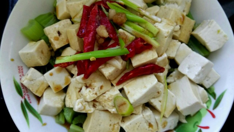 炝拌豆腐,把葱丝红辣椒放在豆腐上,把小碗中的调料浇到豆腐上