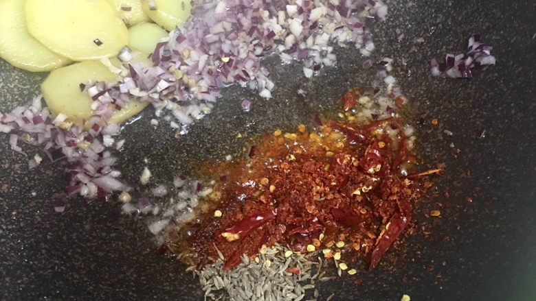 孜然土豆牛肉,出香味，也推至一边，下各种辣椒和孜然粒，慢慢炒出红油，就可以全部均匀翻炒一下