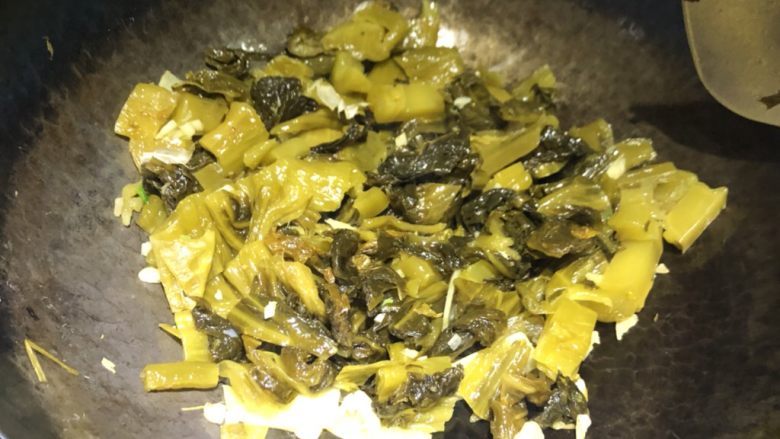 昂公酸菜鱼,锅洗干净,锅中放入少许油,烧至七成热,放入生姜片、蒜末煸香,再放入酸菜煸炒一会。
