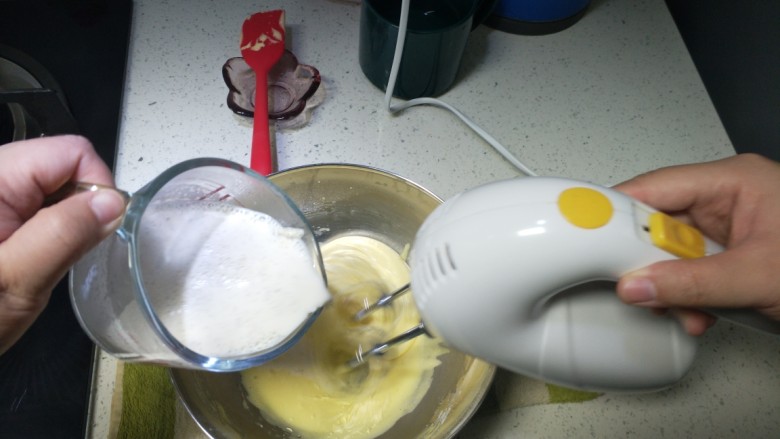 香草卡仕达酱,奶糊慢慢细流倒入鸡蛋糊中,边到边低速搅拌