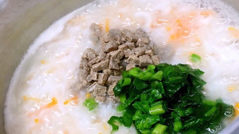 猪肝菠菜蛋黄粥,米粒煮到软烂加入猪肝、菠菜一同煮熟