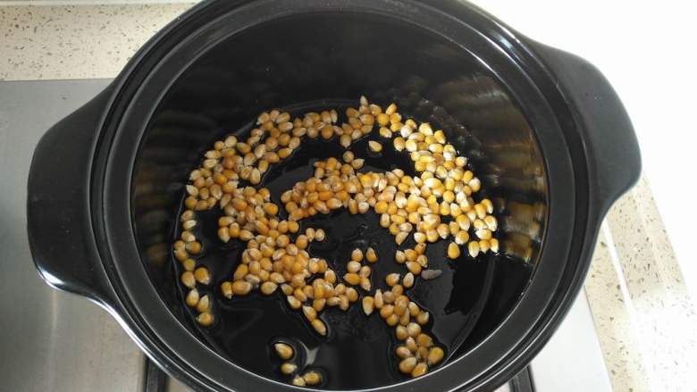 砂锅版爆米花,盖上锅盖开小火,耐心等待,可以听到锅内噼噼啪啪的声音,说明小玉米粒正在变成爆米花,期间要戴上手套,时不时晃动砂锅使玉米粒受热均匀,防止锅糊底,直至噼啪声越来越少,说明玉米粒都变成了爆米花,这时关火。