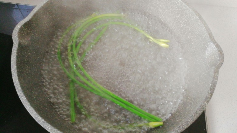 年菜~黄金福袋,锅中烧热水,先放蒜苔焯下水