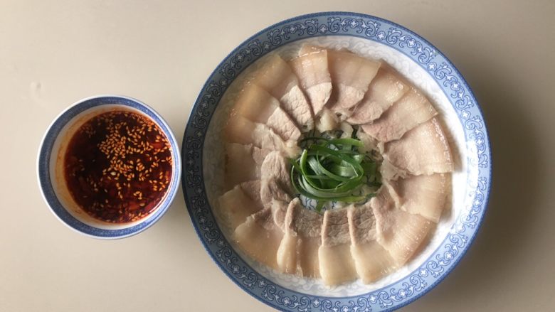 蒜泥白肉,把五花肉切片,要切得波一些,平铺在盘子内,大葱叶子可以切丝放中间装饰一下