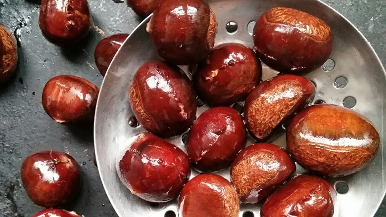 糖炒栗子(史上最简单平底锅版),给我万能的平底锅先预热一下,然后用笊篱捞出板栗放入平底锅中,小火加盖慢慢烘烤。