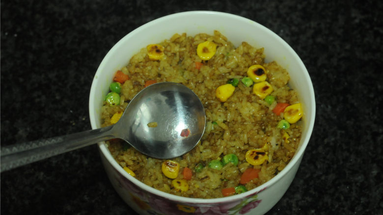 黄金蔬菜炒饭,炒好的咖喱饭装入碗里,用勺子压紧