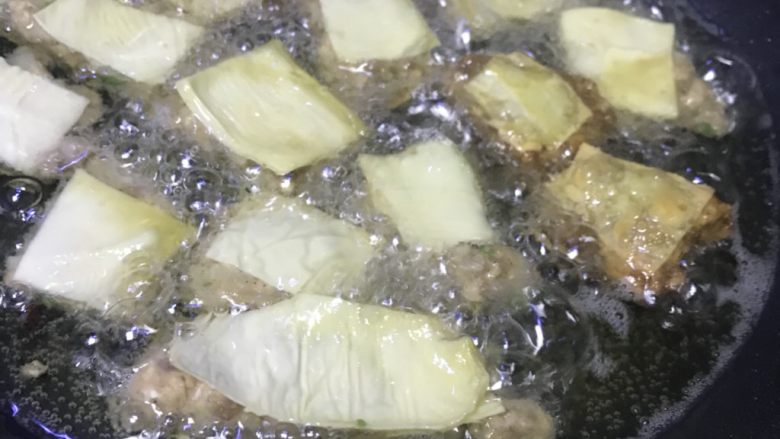 清真小吃-炸松肉,锅里放油,在火上到四五成时,放入松肉块,开始炸。