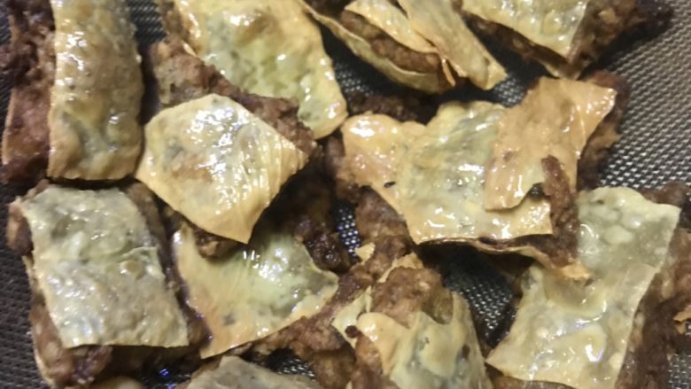 清真小吃-炸松肉,中小火将松肉炸到黄金色的时候,即可将松肉捞出,放在滤网上滤油。