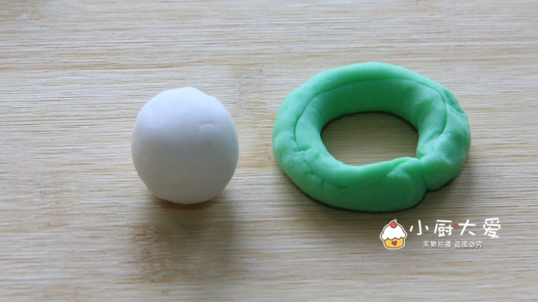 过年菜---福瑞白菜,取一份绿色面团,在手心揉成小长条,然后围成一个圈。取一份白面团揉成小圆形