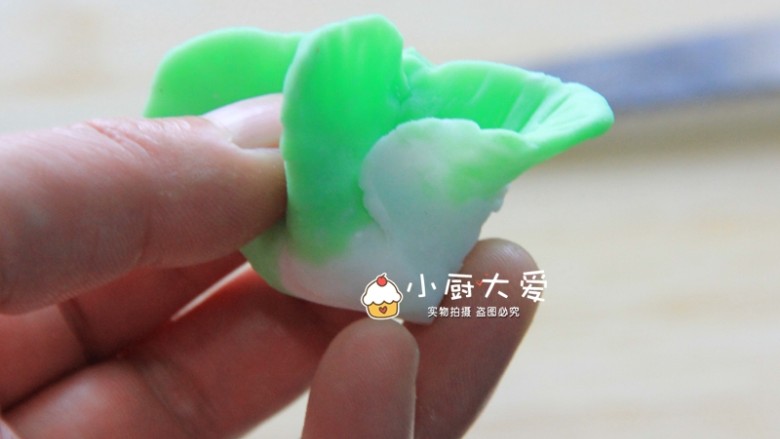 过年菜---福瑞白菜,用大拇指、食指、和中指一起托住,把任意一个叶子放在无名指上