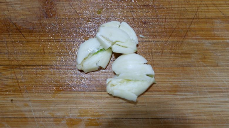 家庭版五花肉闷茄子(无水版),蒜瓣先用刀压扁。