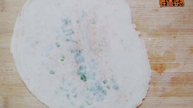 盘丝饼,用手捏把饺子皮的边缘,以防油和葱会漏出。然后用擀面杖从中间向外面按压
