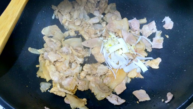 辣白菜五花肉,加入葱蒜,翻炒1分钟。