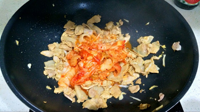 辣白菜五花肉,把辣白菜下锅,大火翻炒2分钟,让肉和辣白菜充分融合。