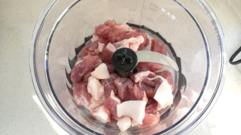洋葱猪肉包,把猪肉切成小块,放入料理机中
