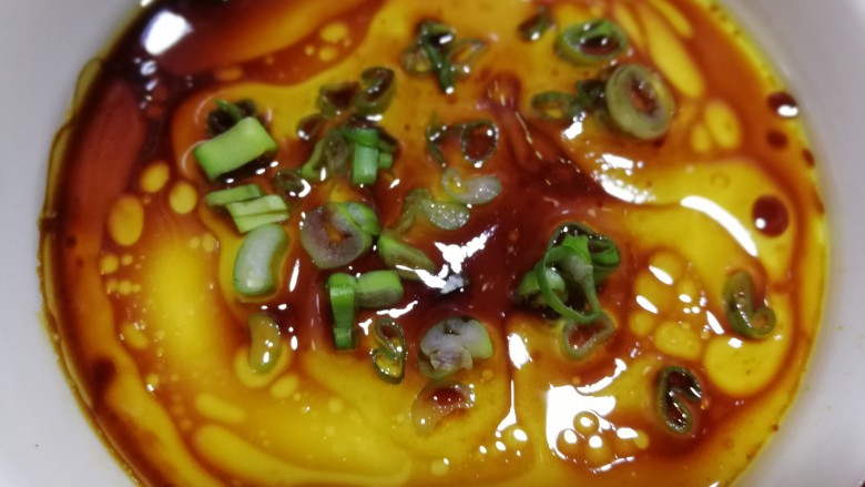 牛奶鸡蛋羹,8分钟后,蒸好的蛋羹从锅内取出,扯掉保鲜膜,放入<a style='color:red;display:inline-block;' href='/shicai/ 692'>酱油</a>,香油,葱花就可以吃了。蛋羹细腻,口感香滑。2018.2.7制作