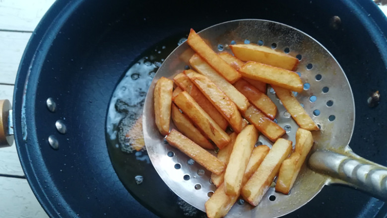 【干煸大虾土豆条】,锅加油烧热,下入土豆条炸至金黄熟透,捞出控油待用