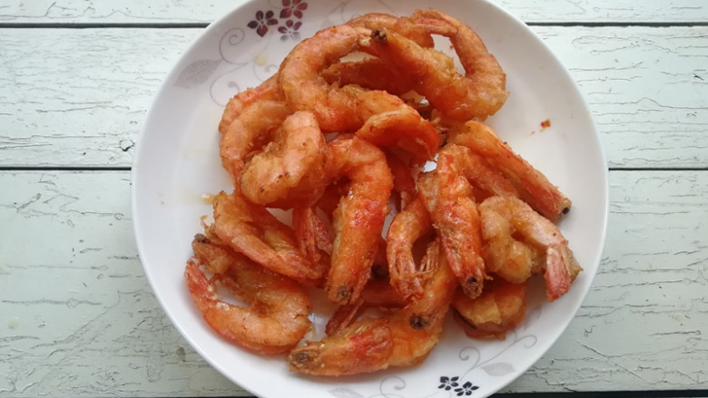 【干煸大虾土豆条】,升高油温至7-8成热,下入大虾复炸,将大虾炸至外皮酥香,将大虾捞出控油,待用