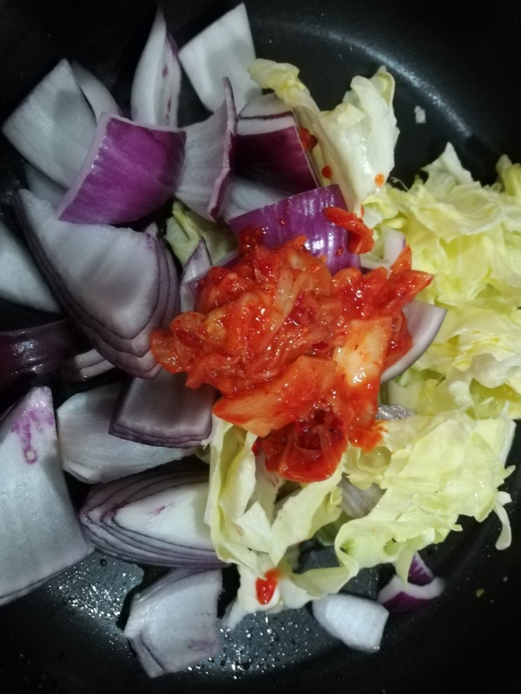 冬日佳节暖心韩式部队火锅(附详细蔬菜刻花处理步骤),放入切成块的<a style='color:red;display:inline-block;' href='/shicai/ 6228'>葱头</a>和<a style='color:red;display:inline-block;' href='/shicai/ 111'>圆白菜</a>，加入<a style='color:red;display:inline-block;' href='/shicai/ 9232'>韩式泡菜</a>炒半分钟。