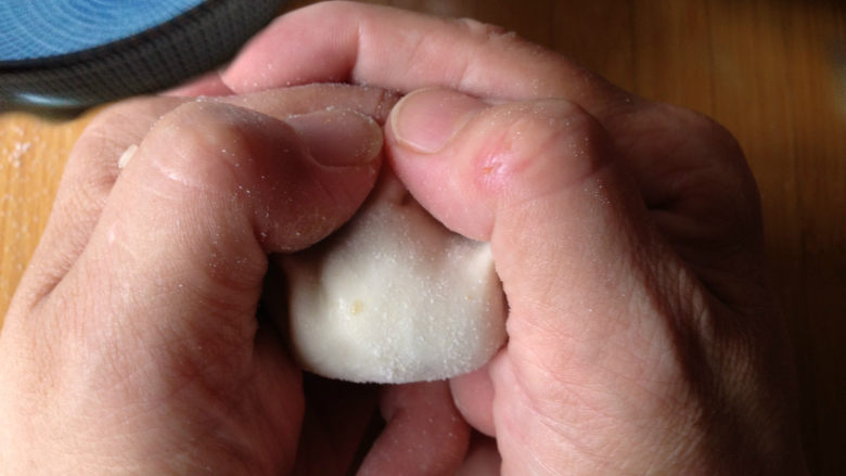 年味饺子——经典韭菜虾仁馅（久财之意，用之不竭）,两片对折，先把中间捏在一起，然后左手食指与拇指夹住左边饺子皮和右手食指与拇指夹住右边饺子皮合力把饺子稍微向中间挤压捏紧（手法类似于过年拱手说：恭喜恭喜）

