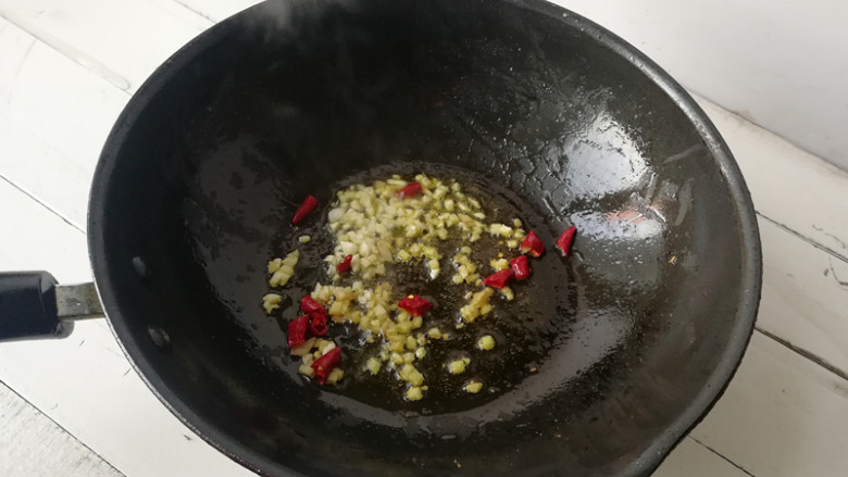 【蒜薹炒鸡丁】,下入姜末,蒜末,干辣椒段爆香