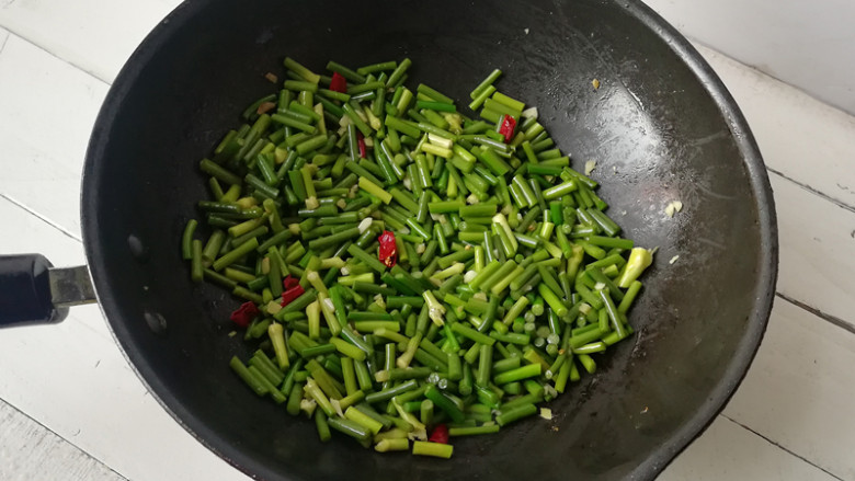 【蒜薹炒鸡丁】,下入蒜薹段翻炒至颜色变深绿,至断生