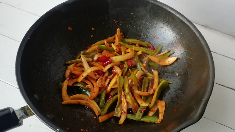 【干煸土豆片】 ,下入尖椒和洋葱翻炒均匀