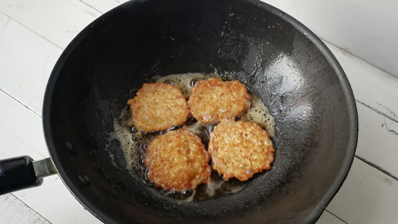 【黄金米饭饼】,放在锅内,用勺底拍成圆饼状,将一面煎制定型