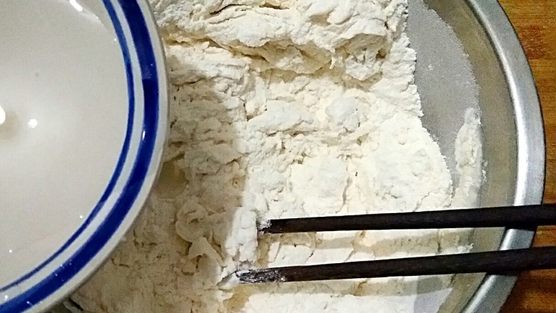 椒盐盘丝饼,在面粉中少量多次加入温水,用筷子搅拌成雪花状。