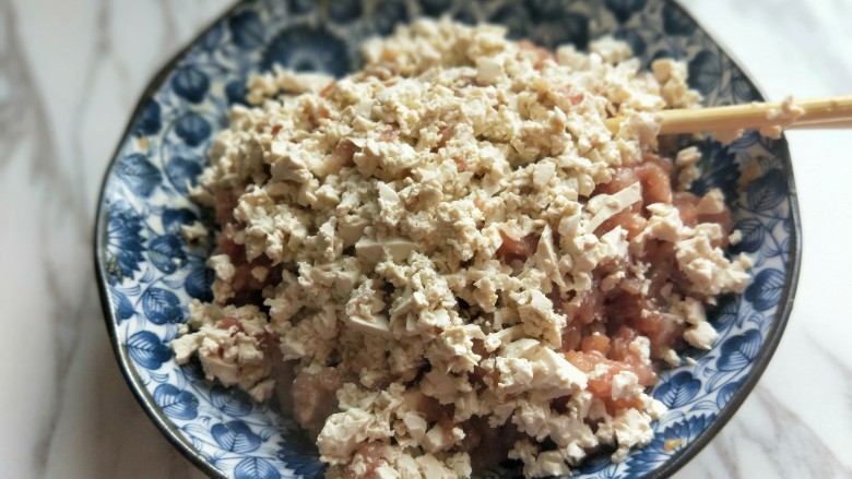 年货必备的自炸肉丸子,碎豆腐加入调好味的肉糜中,再次拌均匀。