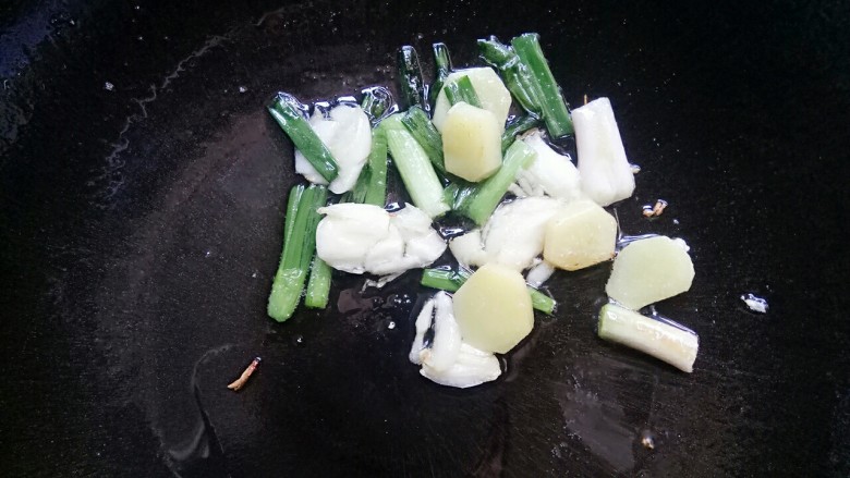 家常煮草鱼,锅里放点油,油热后放入姜葱蒜头煎一下