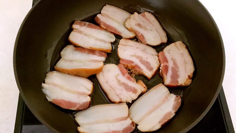 土豆烧腊肉,锅烧5分热的时候放入腊肉,小火煎制