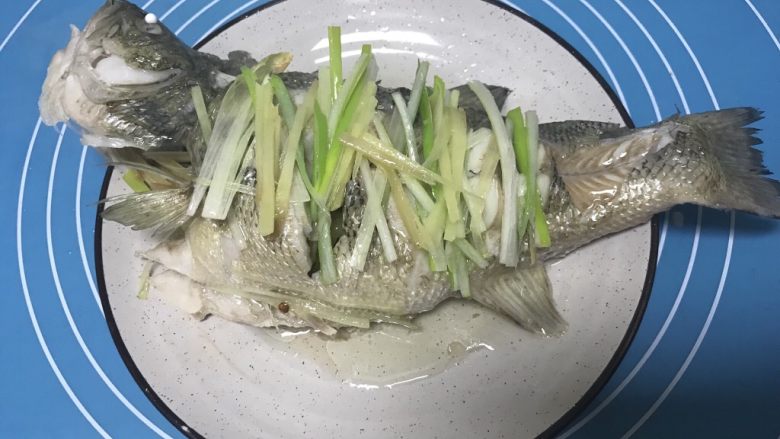 清蒸鲈鱼,迅速将热油均匀淋到鱼身上。