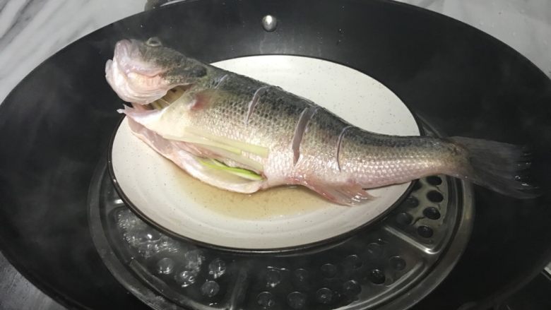 清蒸鲈鱼,锅中水开放入鲈鱼， 大火蒸7分钟左右即可，关火后虚蒸1分钟，出锅。